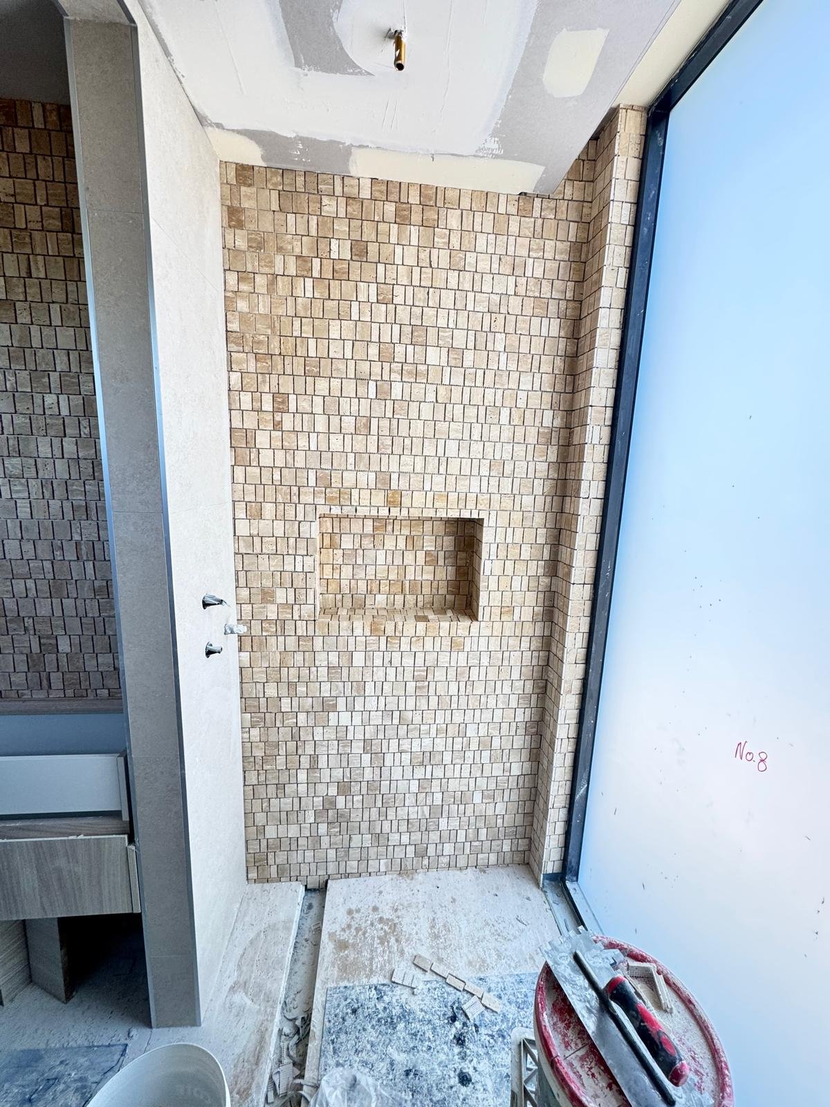 Travertine mosaic shower with niche detail